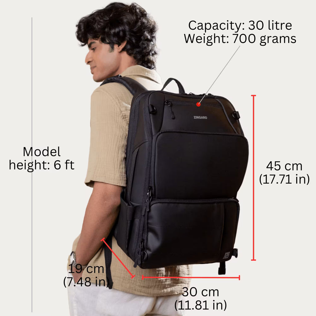 A man wearing a black Zingaro brand backpack, shown from the side with dimension lines and text overlays indicating the backpack's capacity, weight, and measurements.